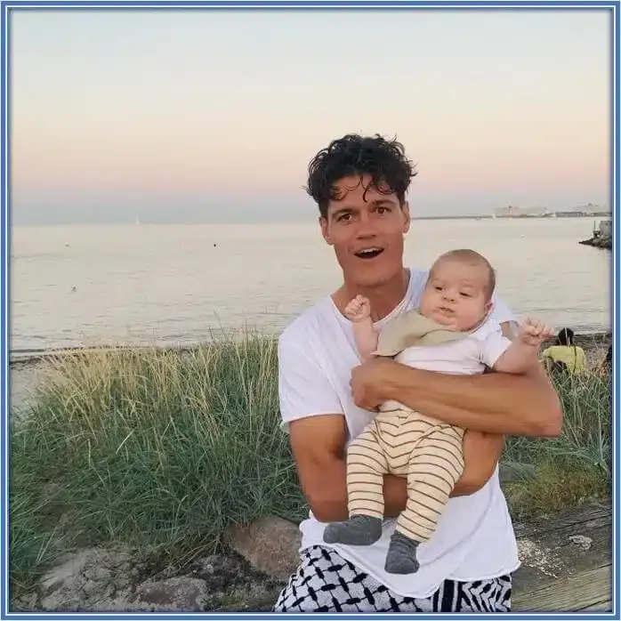 He is actually replicating how his father held him when he was a kid. Indeed, his child makes him a happy dad.