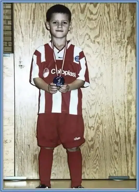He was so happy to have tasted victory on the pitch as he holds onto his medal.