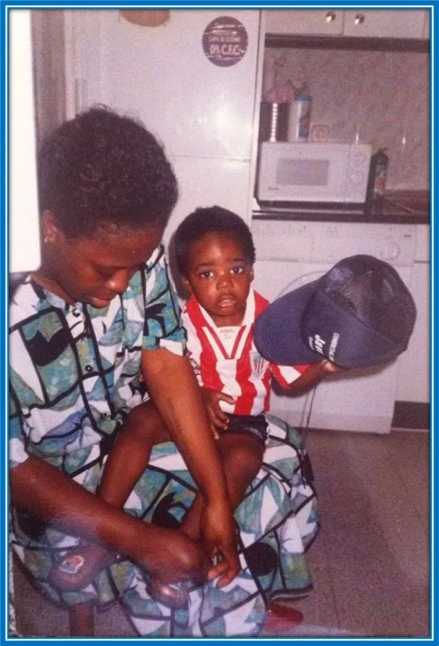 Maria Williams is pictured buckling young Inaki's shoes.
