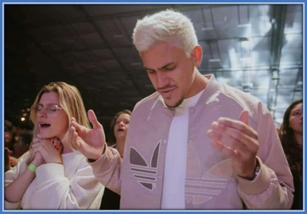 Pedro Guilherme and his girlfriend, Fernando Nogueira, worship God sincerely during church service.