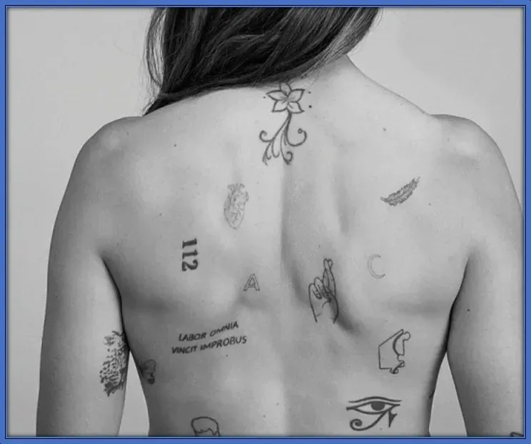 Alexia has tattoos all over her back and ink on her arms, wrists, ankles, and lower leg.