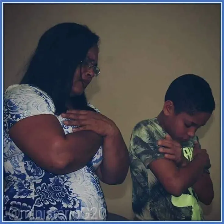 Vitor Roque and his mother (Herc&iacute;lia Roque Ferreira) share a heartfelt prayer session during his childhood. This reflects the footballer's deep-rooted Christian faith, which exists to this day.