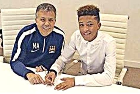 Signed, sealed, delivered: A beaming Jadon Sancho proudly signs his first professional contract, marking a significant milestone in his footballing journey.
