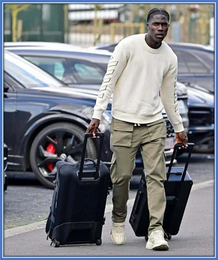 The footballer is pictured carrying his luggage away from his car and through the park. Accepting to do things himself embodies his laid-back lifestyle.