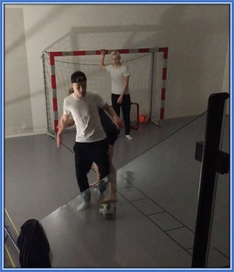 Rasmus and his twin brothers, Oscar and Emil, pictured playing football in their basement. The Hojlund family's basement football pitch was designed to protect their living room from the boys' energetic play.