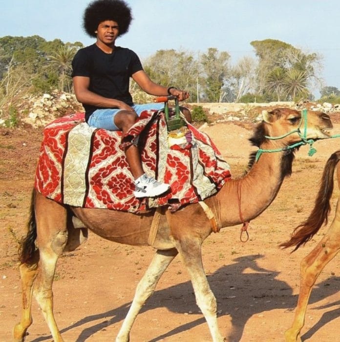 Hamza Choudhury taking a pose with a Camel.
