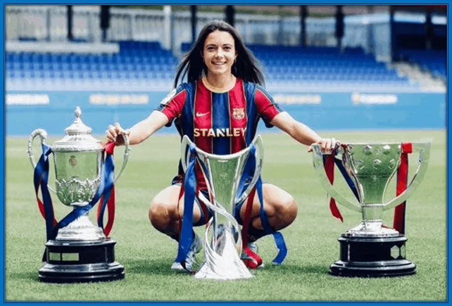 Here, she poses with her Copa de la Reina, UWCL and La Liga Trophies.