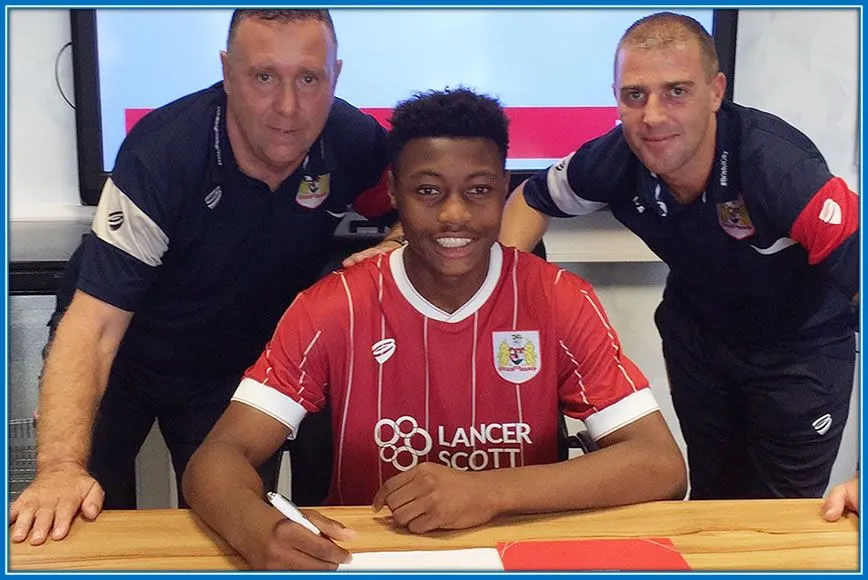 Antoine Signs his first club after his Academy session in Bristol City. On his side are the Managers of his new team.