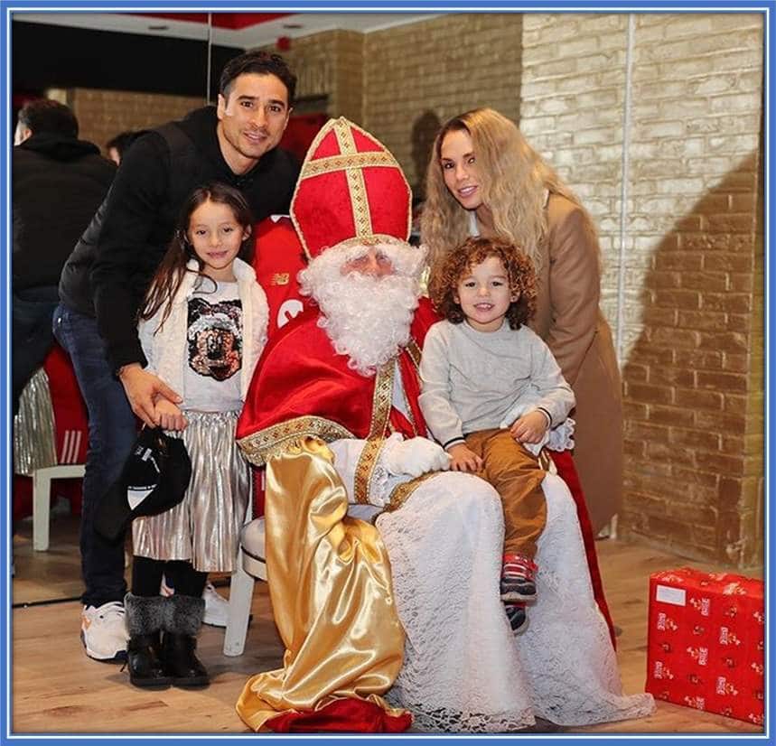 Memo, his wife (Karla Mora), and Children (Luciana and Luciano) pose for a photo with Saint Nicholas.