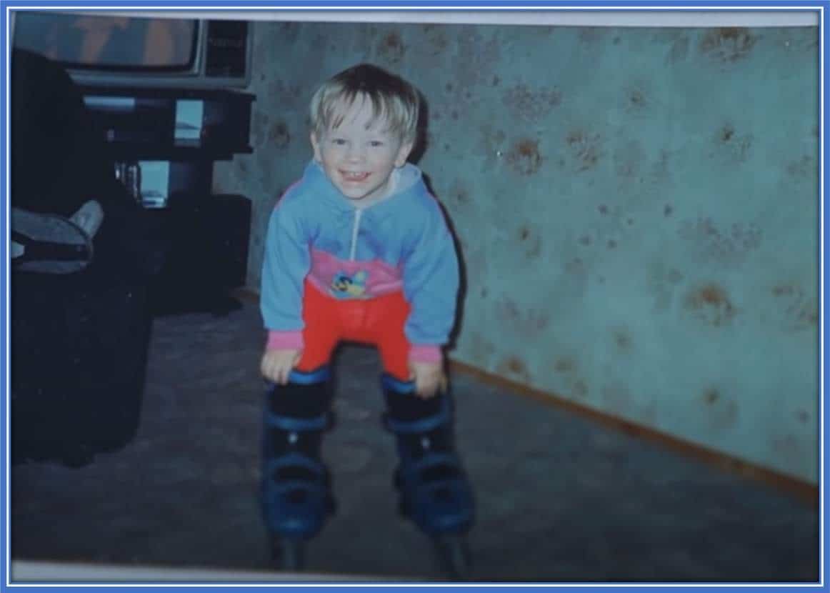 An excited Piotr poses for the camera in his snow shoes, right inside his family's living room.