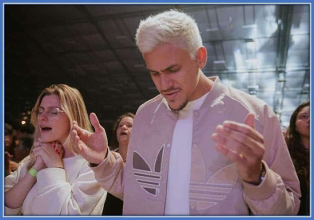 Pedro Guilherme and his girlfriend, Fernando Nogueira, worship God sincerely during church service.