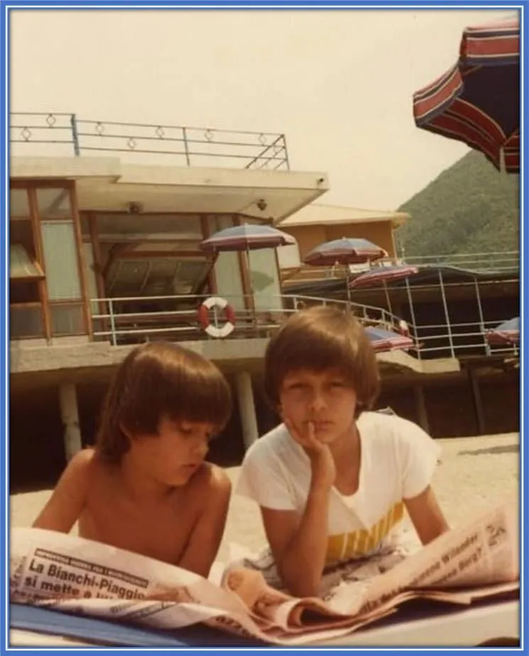 Learning between lines: The Inzaghi brothers, Simone and Filippo, unwinding on a sunny outside after a day of honing their football skills. With a newspaper in hand, Simone deepens his understanding of football, while their shared passion for the game continues to strengthen their bond.