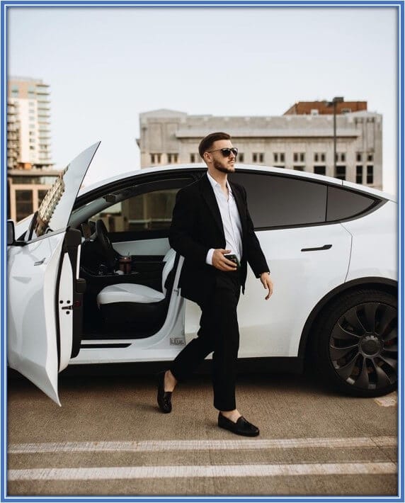 A nice view of Paul Arriola stepping out of his white Tesla.
