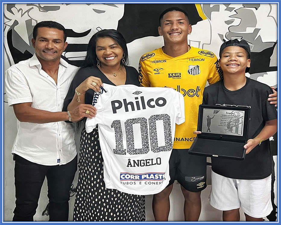 In this photo, Angelo, the family's pillar of support, celebrates his 100th game milestone with Santos — a cherished moment for his family. He is proud to have donned the Santos jersey, a club that once had legends like Pele, Neymar, and Coutinho, is palpable.