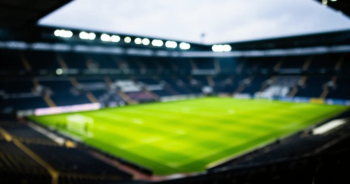 Football midfielder training on pitch under floodlights