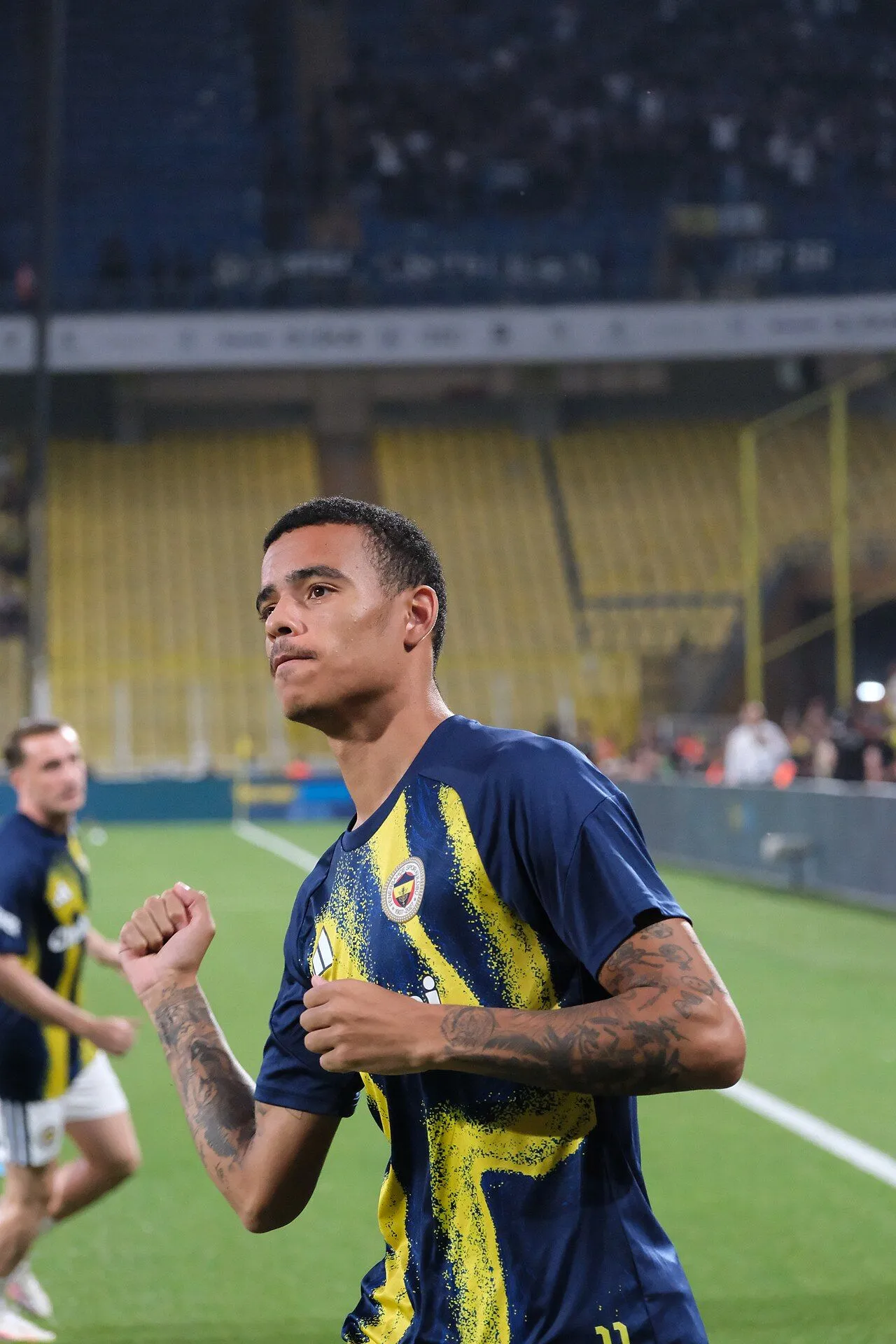 Joueur de football en action sous les projecteurs d'un stade lors d'un match du soir