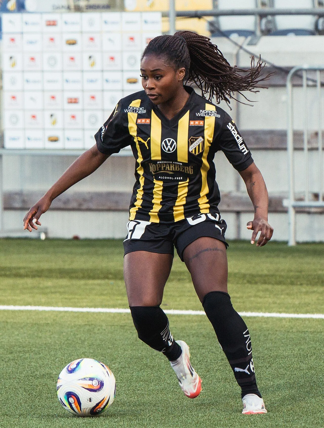 Swedish female footballer in action on pitch with full stadium crowd