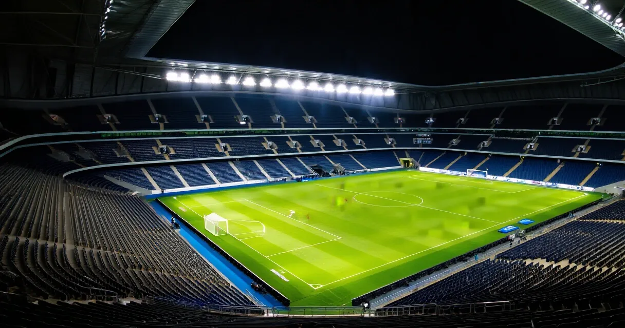 Footballer celebrating goal on debut in La Liga stadium, teammates around him
