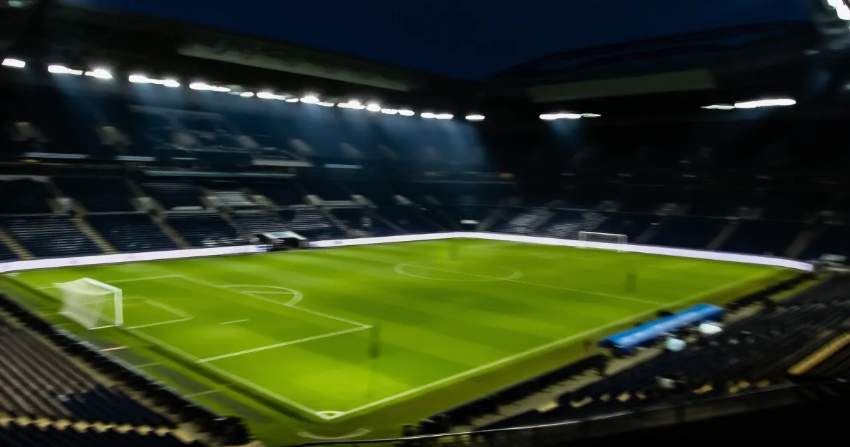 Arsenal footballer training on pitch at stadium during golden hour