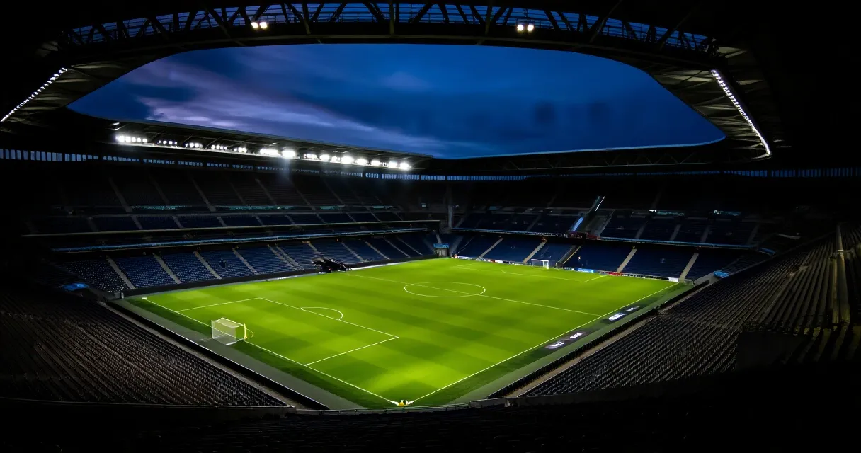 Footballer training on pitch before Premier League move, stadium lights background
