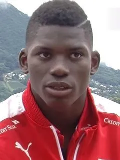 Professional footballer sprinting in training, natural light, stadium backdrop
