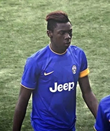 Italian striker in purple football kit sprinting on a Serie A pitch in a packed stadium