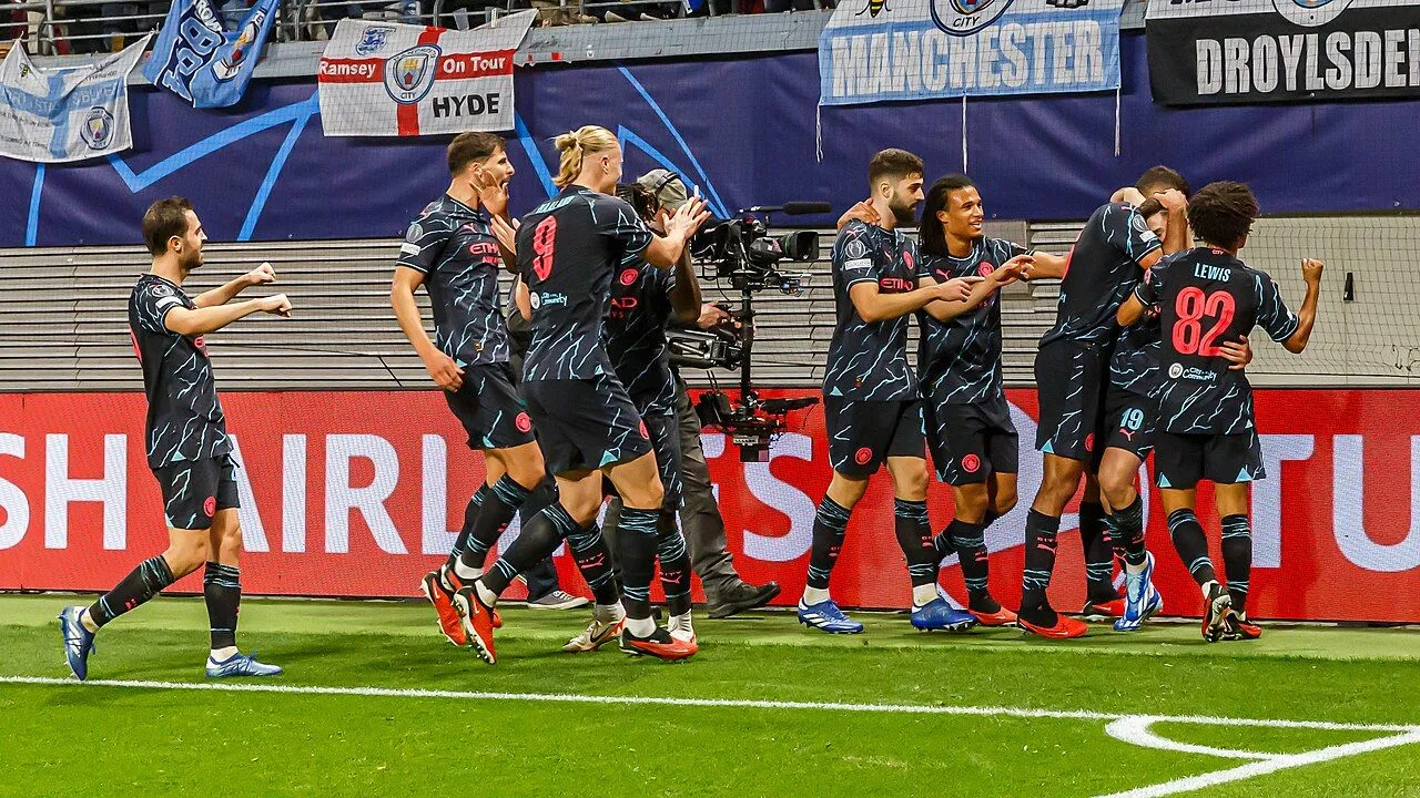 Striker celebrating goal in packed Champions League stadium at night