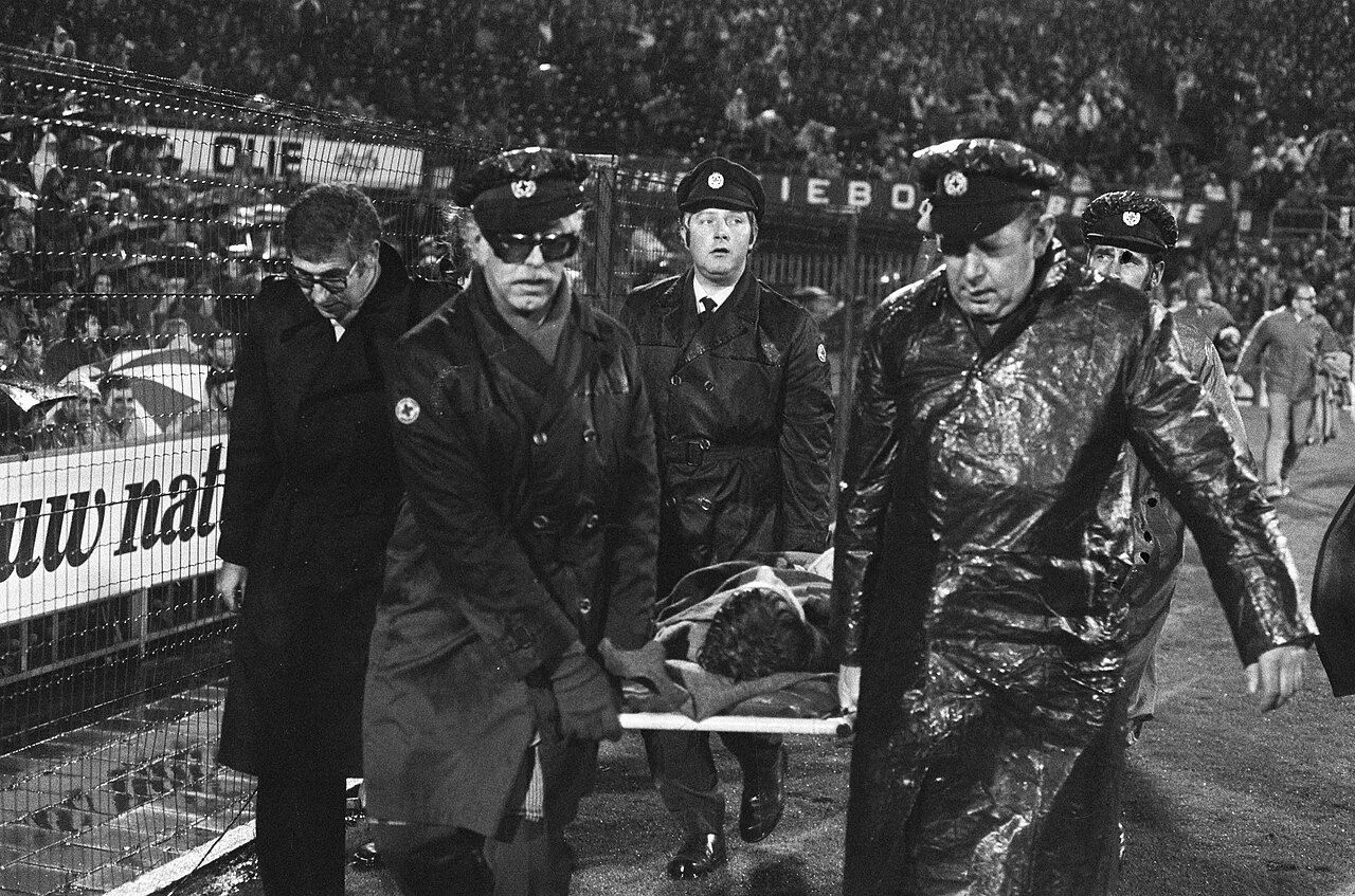 Volle uitvak met fans tijdens een Champions League-avondwedstrijd onder felle stadionverlichting