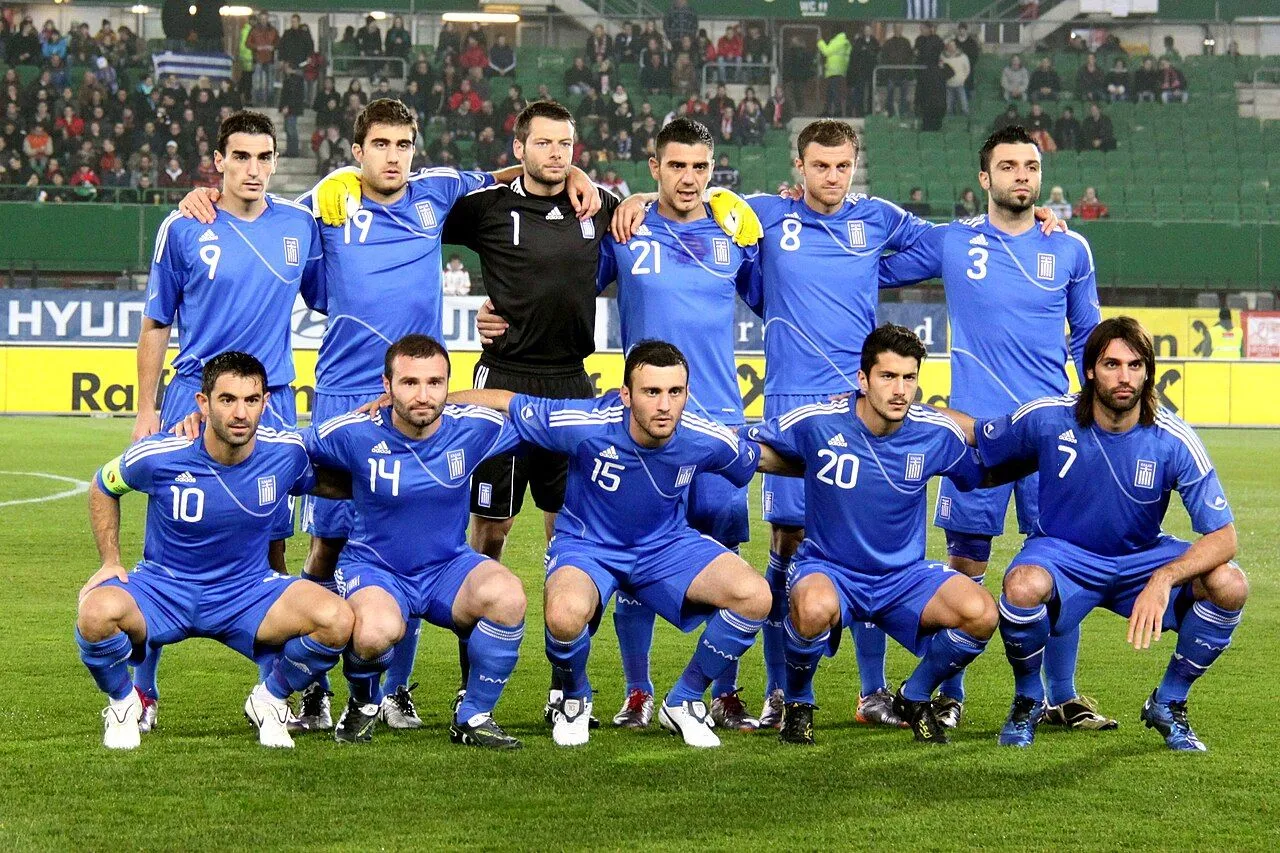 Packed floodlit stadium with fans during a national team football match at night