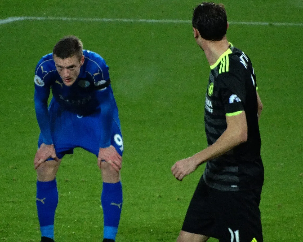 Football striker celebrating goal in Championship stadium under floodlights