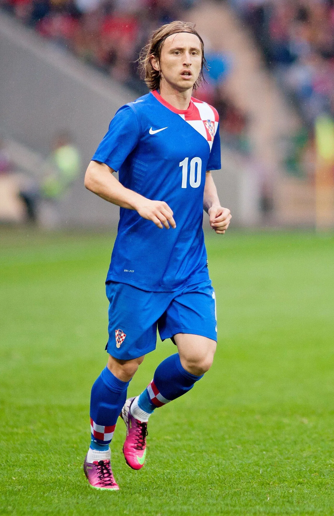 Veteran midfielder on pitch in packed stadium under floodlights