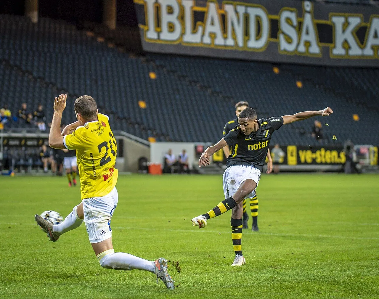 Fotbollsspelare firar mål på en fullsatt, upplyst arena