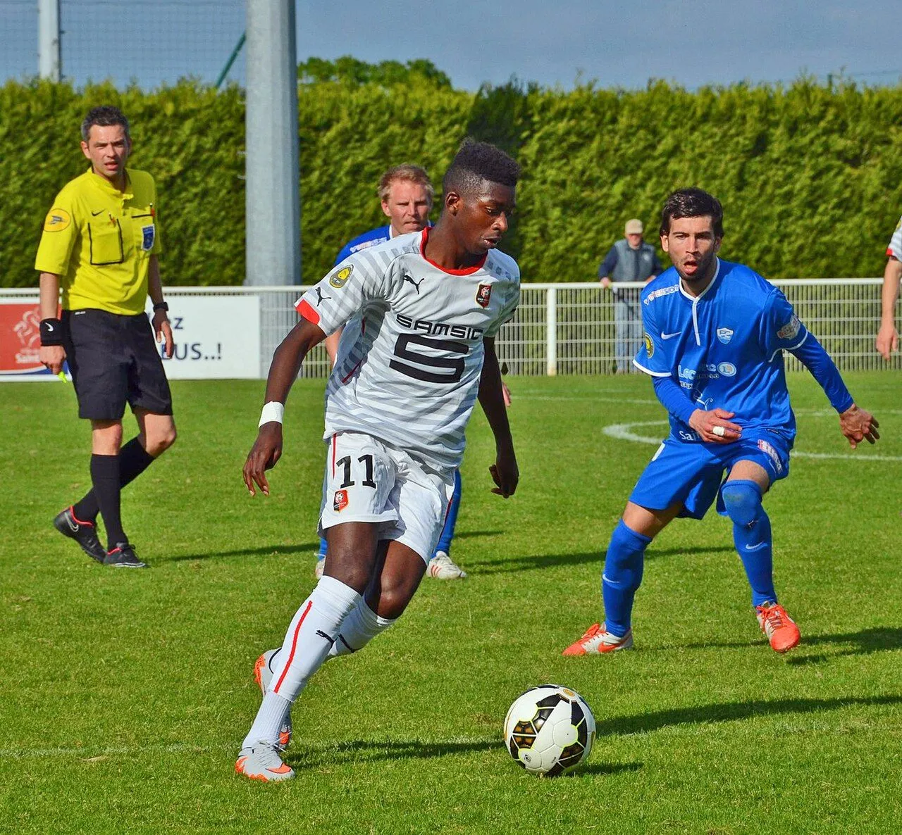 Football player celebrating in packed stadium under floodlights