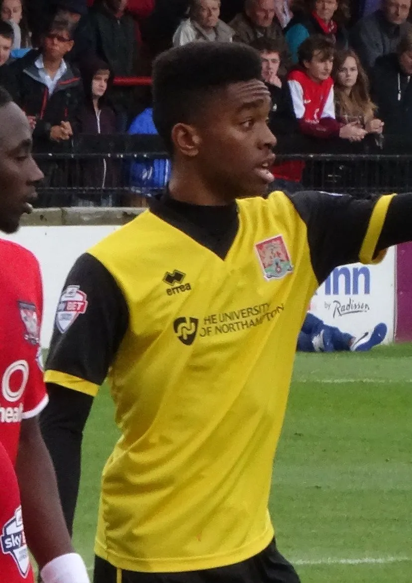Football striker walking through a dimly lit stadium tunnel
