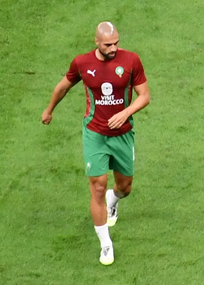 Ajax midfielder on the pitch in a packed stadium under floodlights