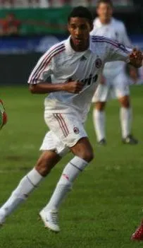 Striker in blue and white celebrates a header goal under stadium lights